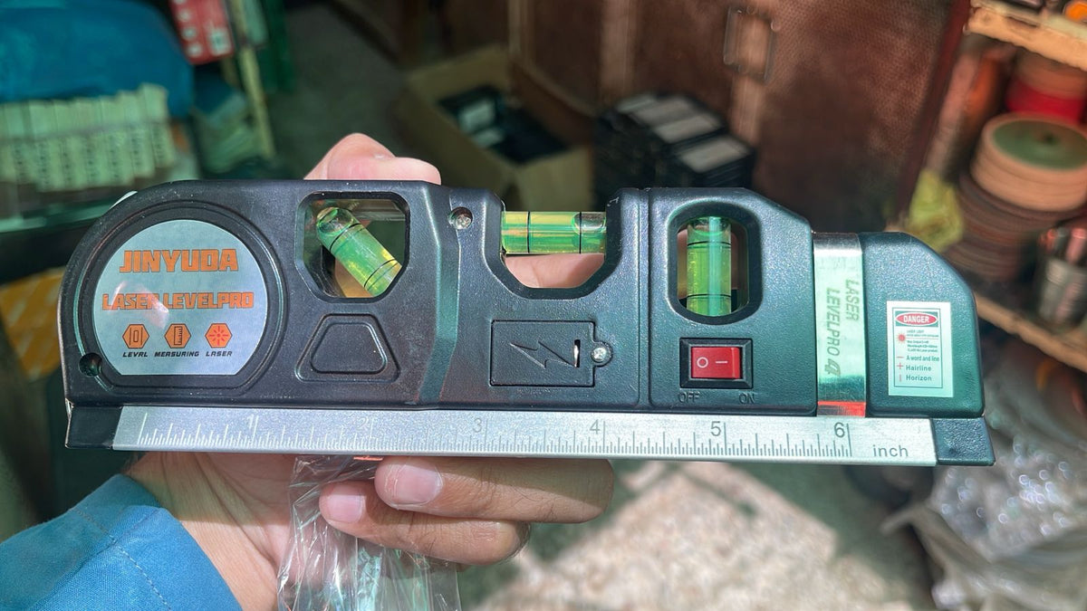 Laser Level Pro 3 in hand aligning a picture frame