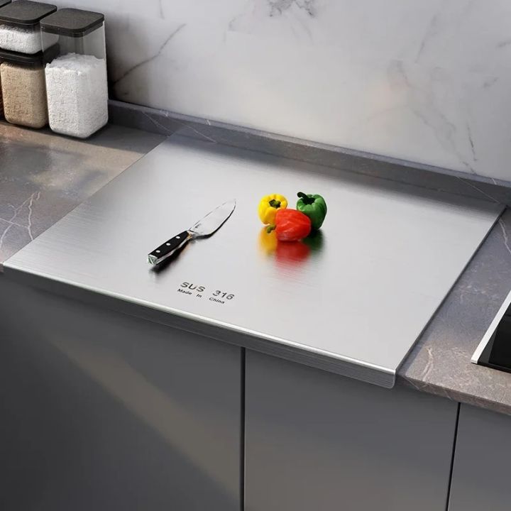 Titanium cutting board 304 stainless steel on kitchen counter with knife and bell peppers