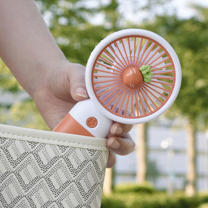 Mini handheld fan carried outdoors, round grille and push button