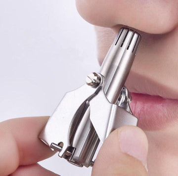 Manual stainless steel nose hair trimmer in use — rounded cutter head gently trims nose hair